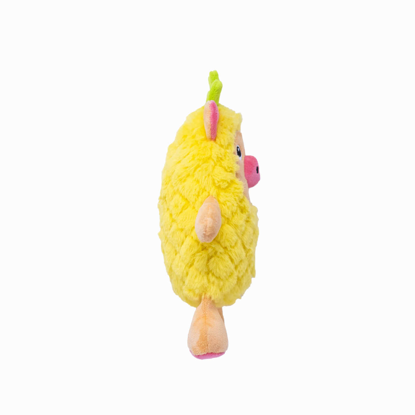 The side view of a plush yellow dog toy resembling a pig in a pineapple costume on a white background